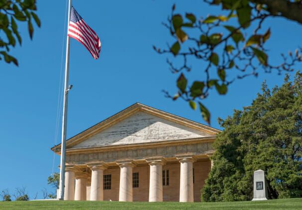 American flag flying over historic neoclassical building with white columns